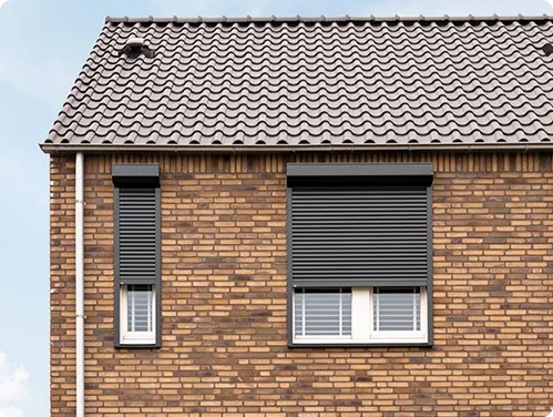 Zwarte rolluiken op een bakstenen huis voor een stoere en moderne uitstraling